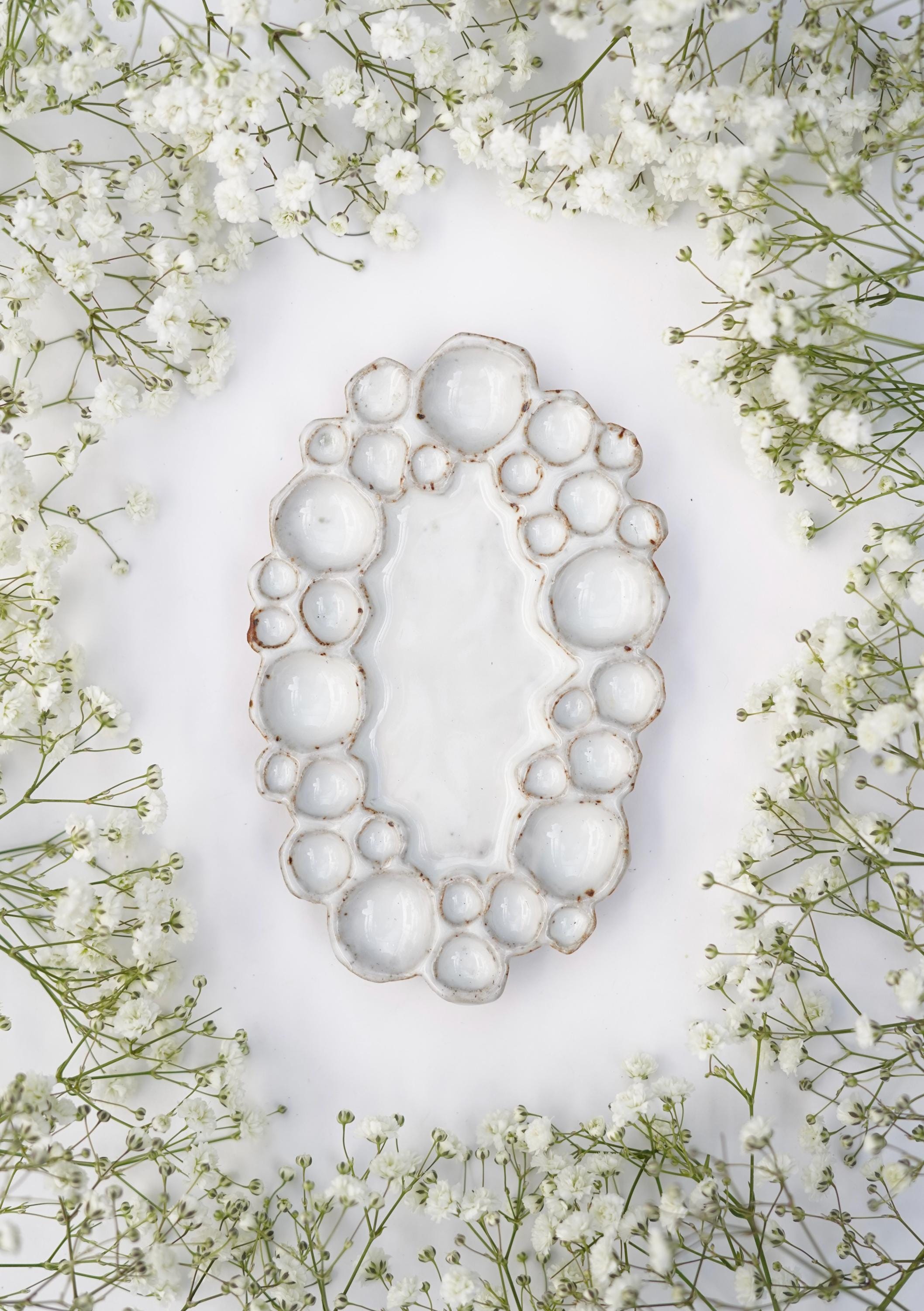 Mini ceramic oval bubble palette against white background with flowers