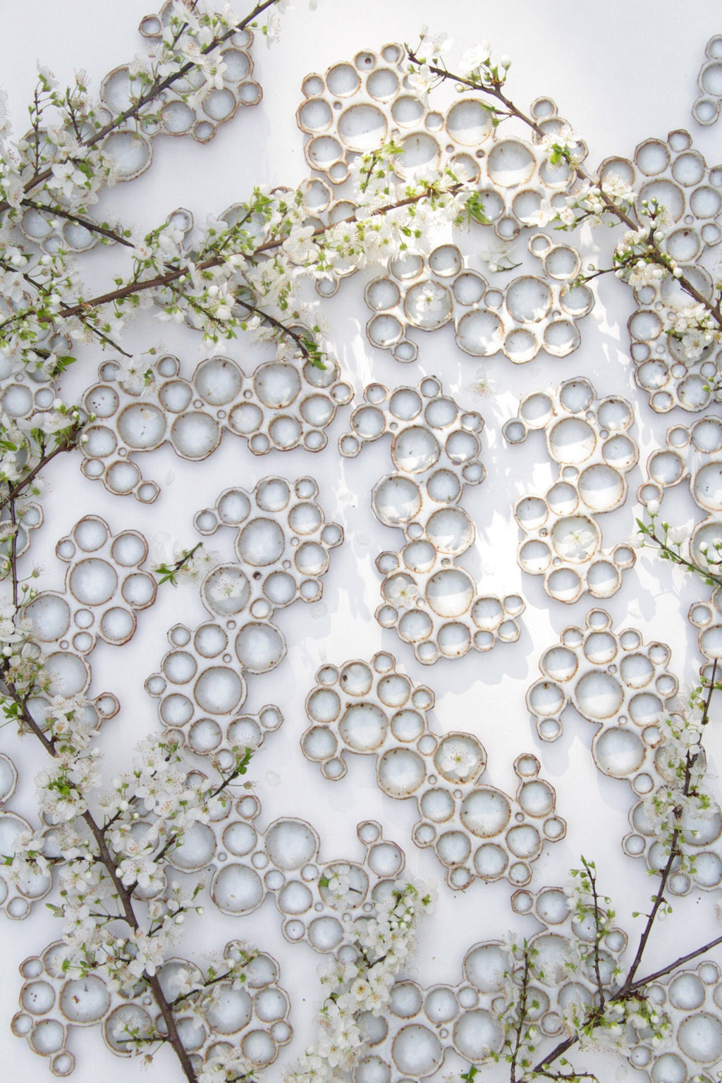 multiple ceramic bubble palettes arranged together against white background with flowers 