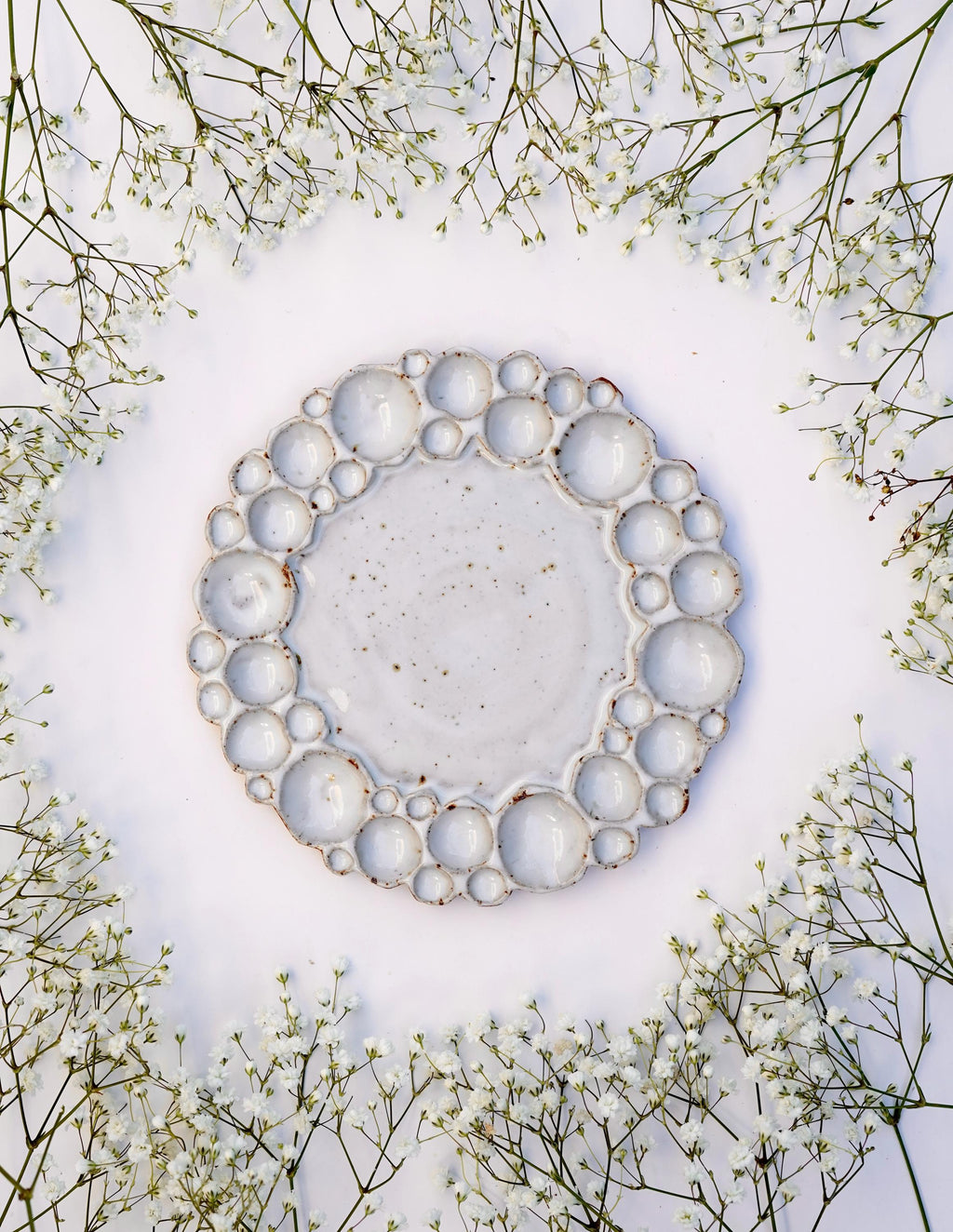 Small size round bubble paint palette against white background with flowers surrounding it 