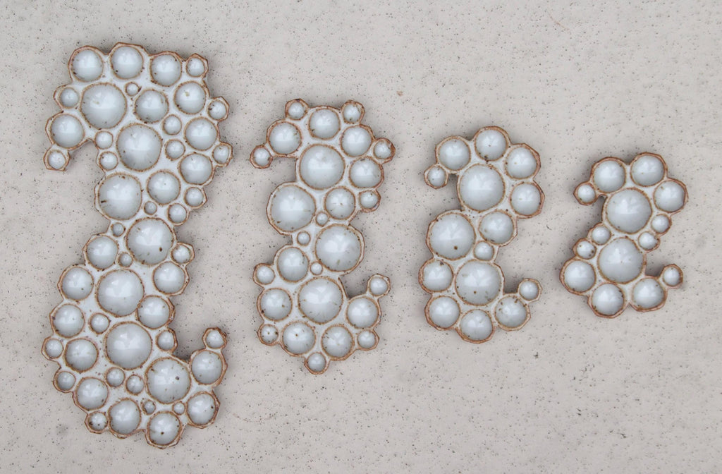 X-large, large, medium and small ceramic bubble palettes lined up next to each other on white background 