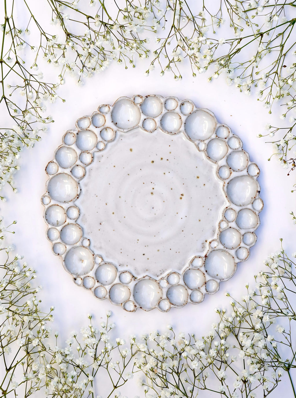 Round bubble palette against white background wit flowers surrounding it 
