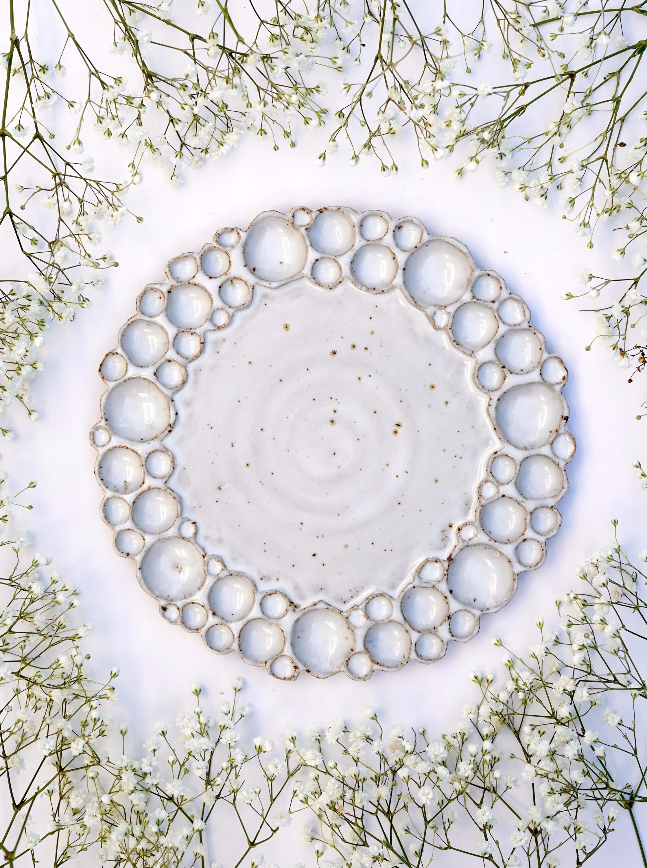 Round bubble palette against white background wit flowers surrounding it 