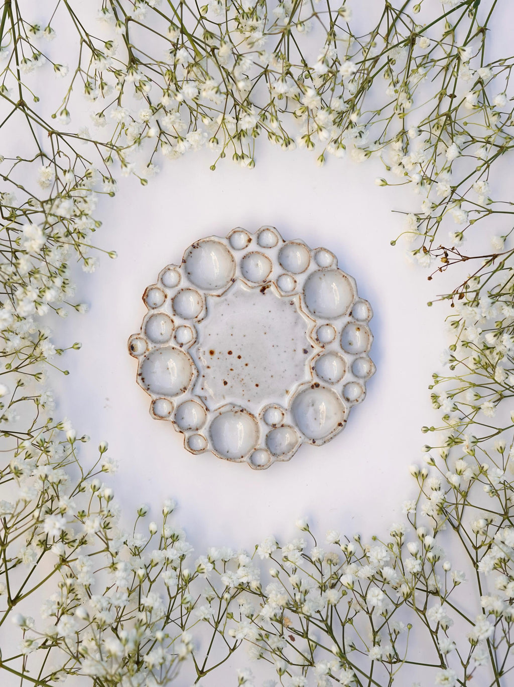 Mini size round bubble paint palette against white background with flowers surrounding it 