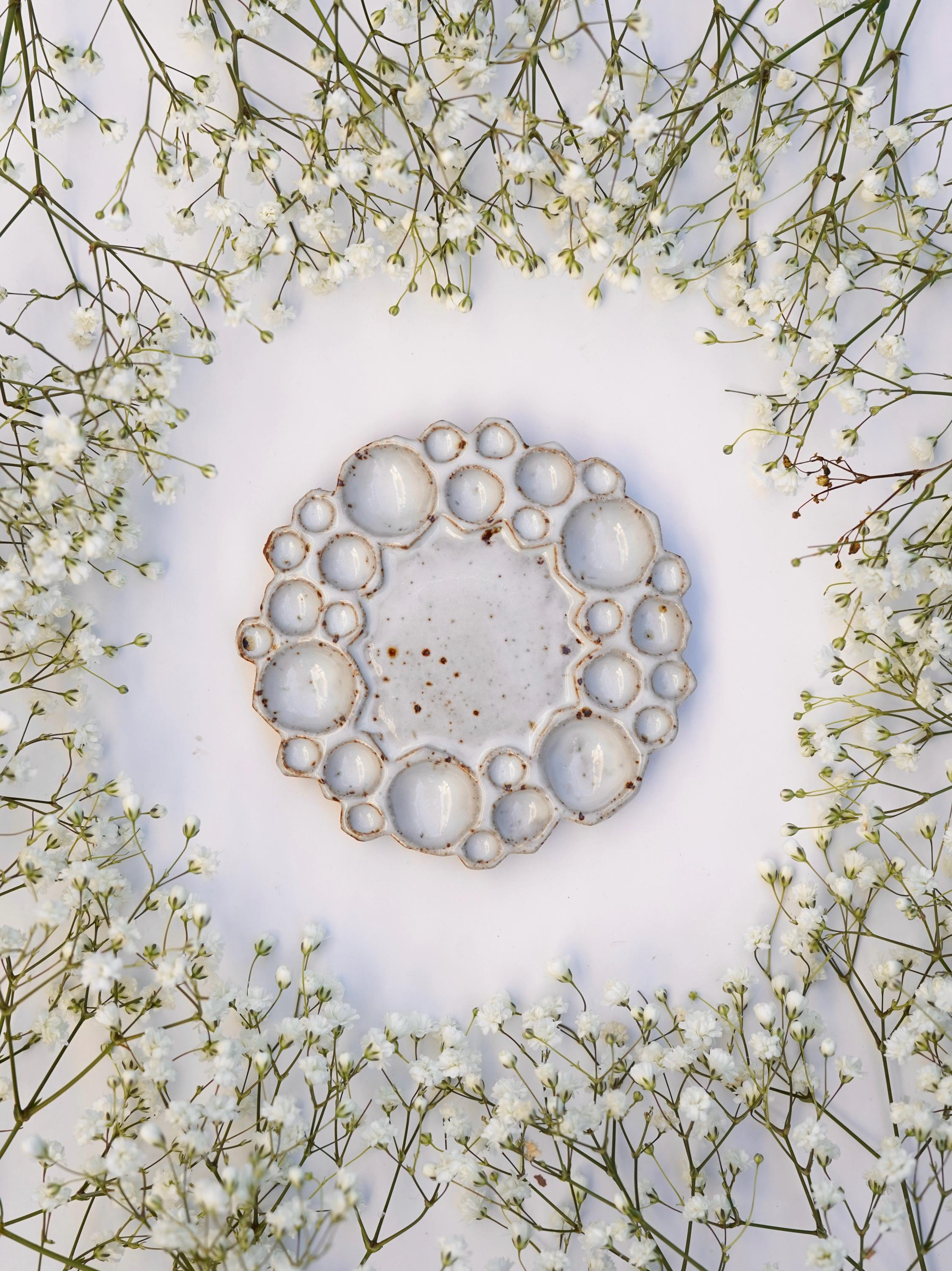 Mini size round bubble paint palette against white background with flowers surrounding it 