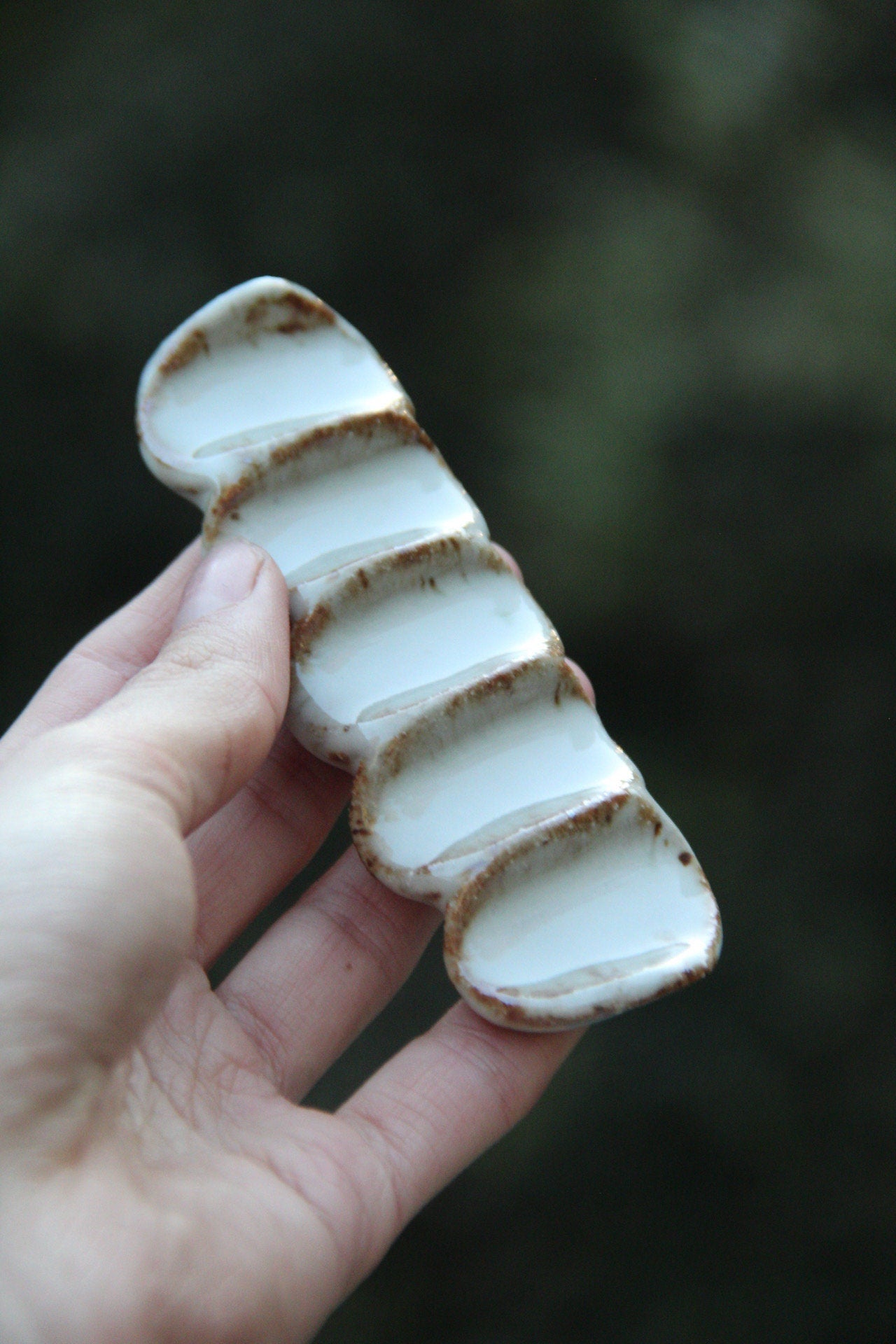 Hand holding ceramic brush rest 