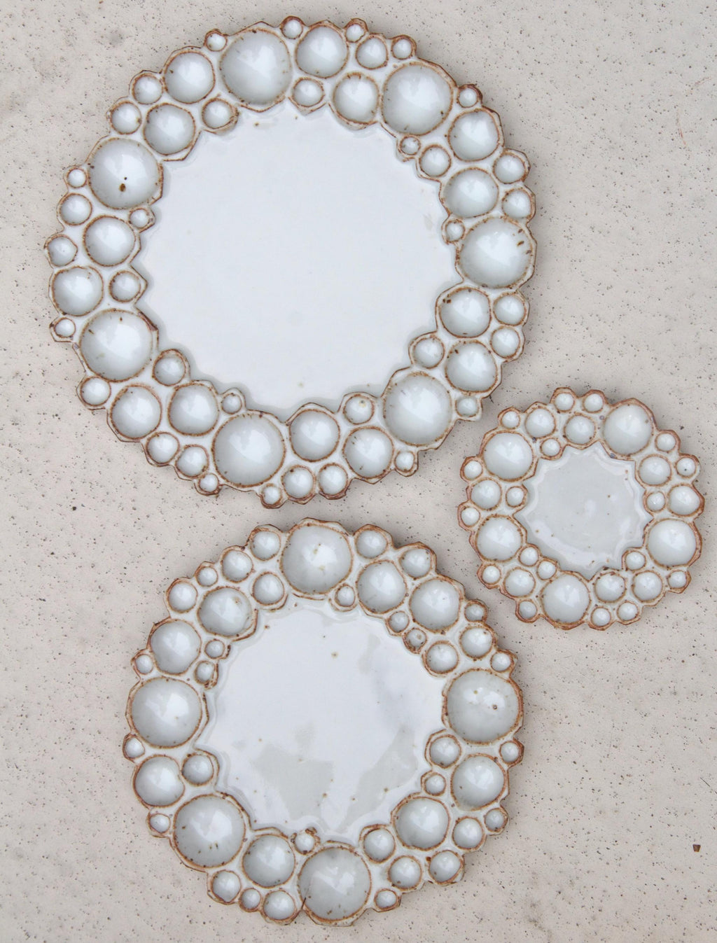Three different sized round bubble palettes beside each other against beige background 
