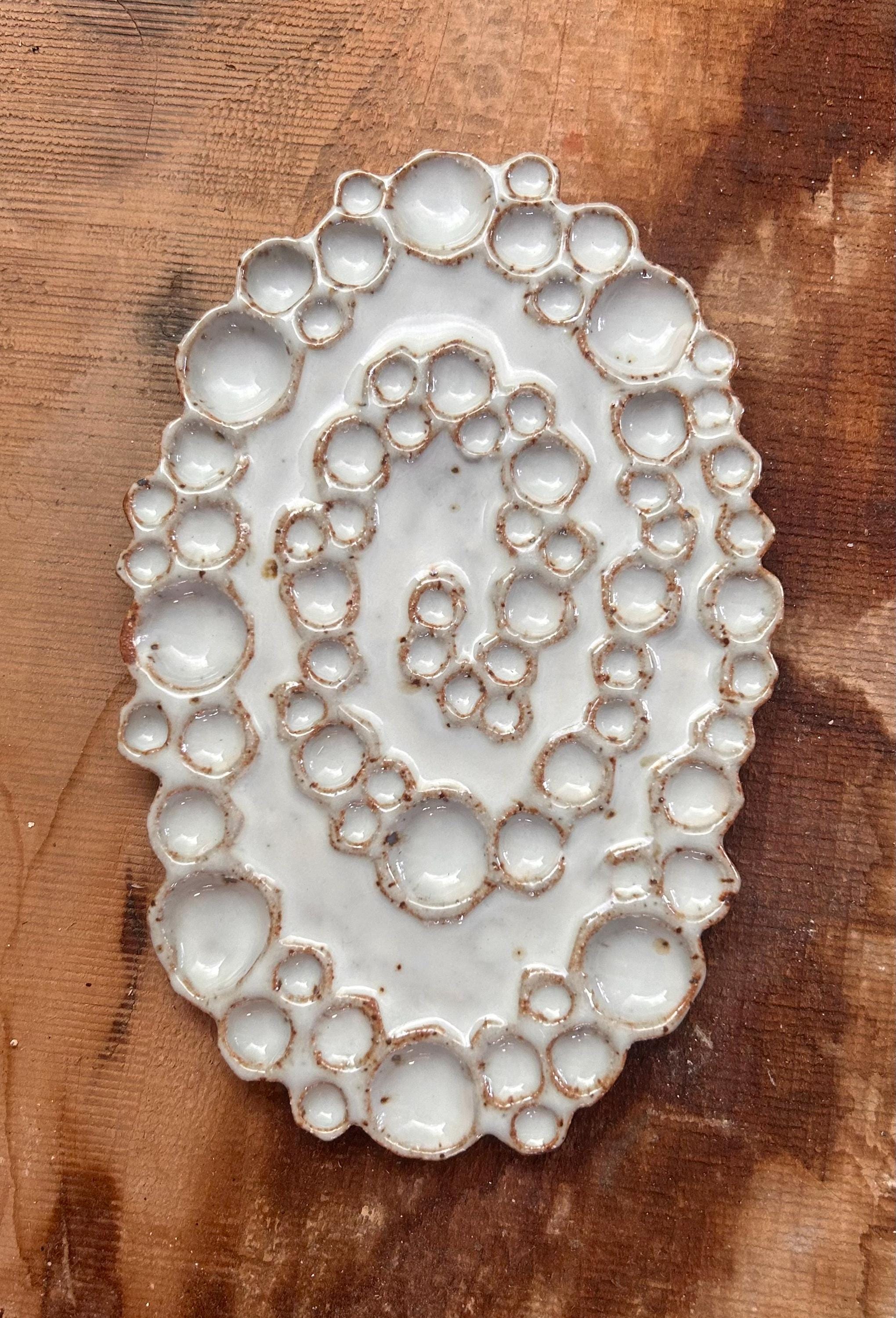 Mini ceramic spiral bubble palette against wood background 